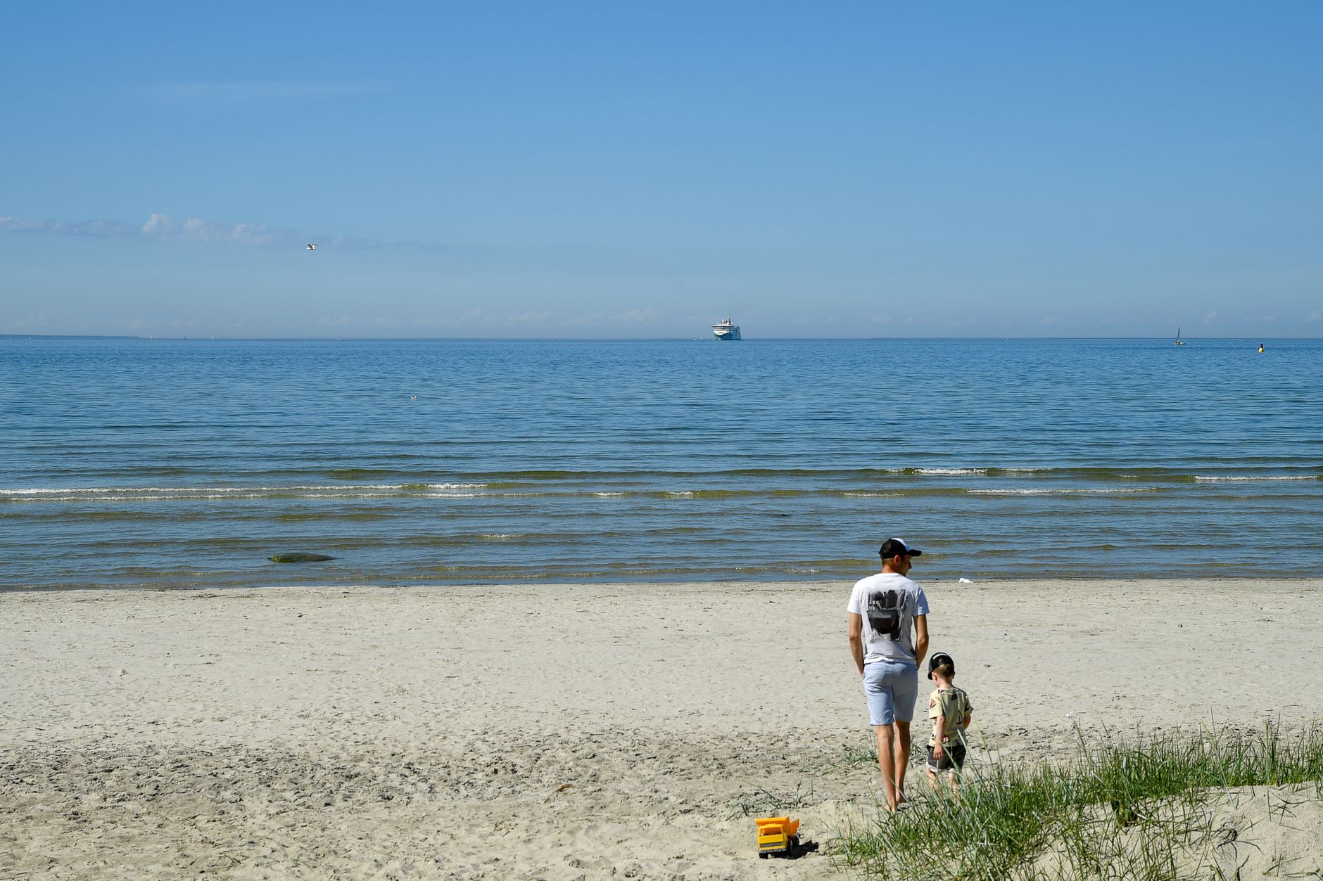 A father and son enjoy a sunny day on the sands of Tallinn Bay, Estonia.
