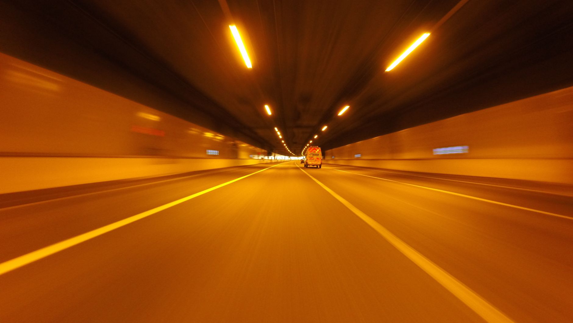 Experience the thrill of speed with this long exposure of a vehicle driving through a tunnel at night.