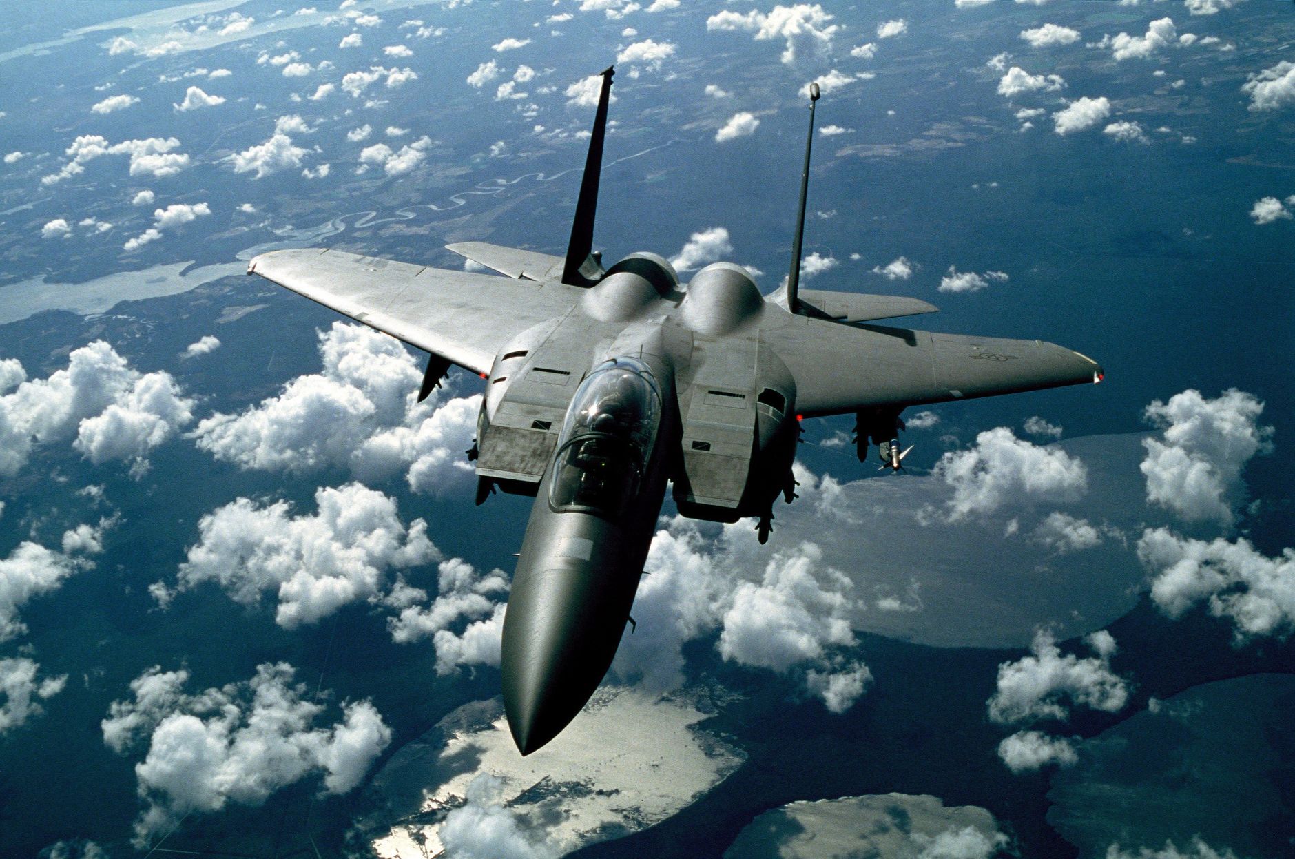 A stunning aerial view of a military fighter jet flying high above the clouds.