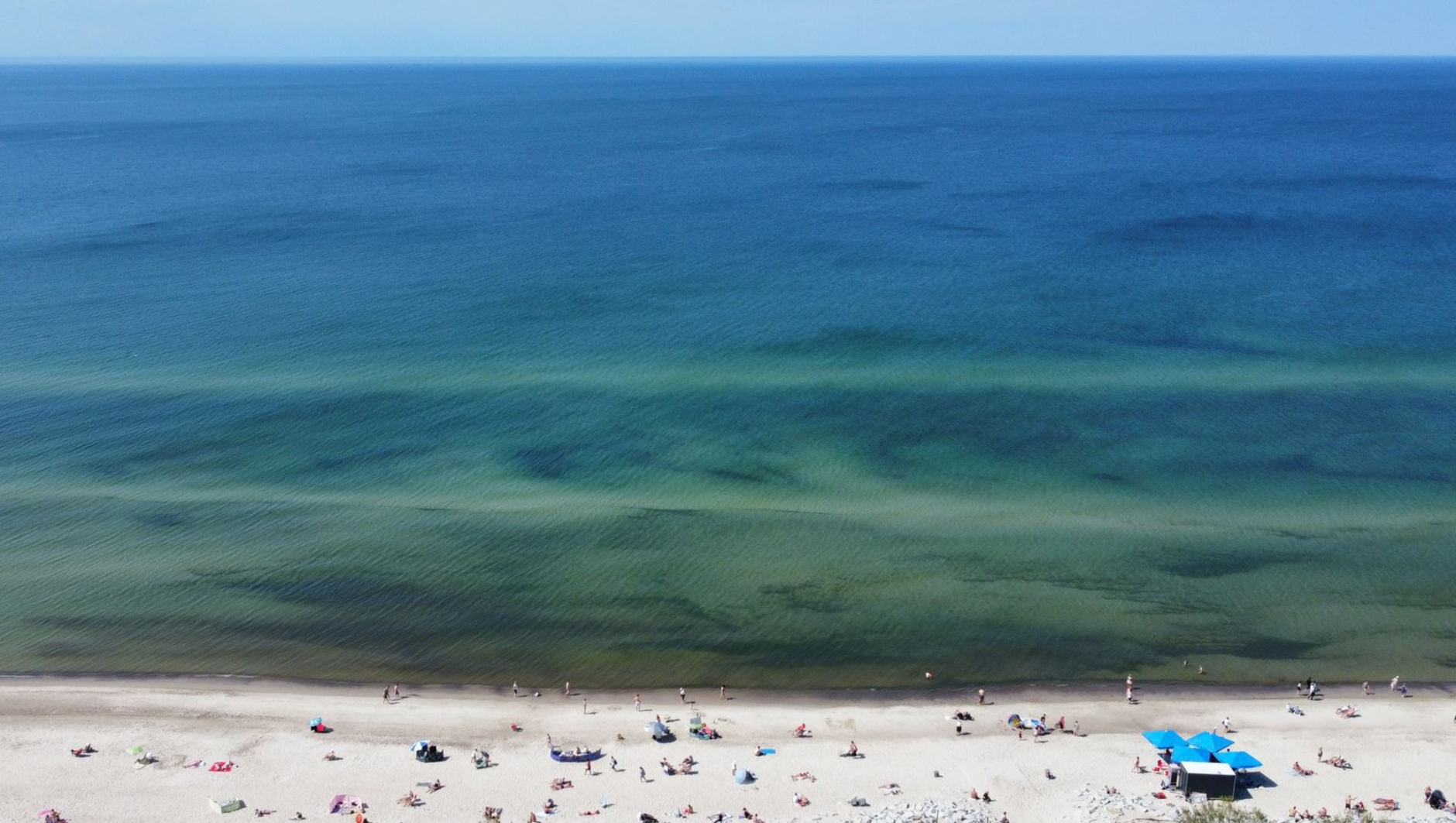 Aerial view of a sandy beach along the Baltic Sea on a sunny day.