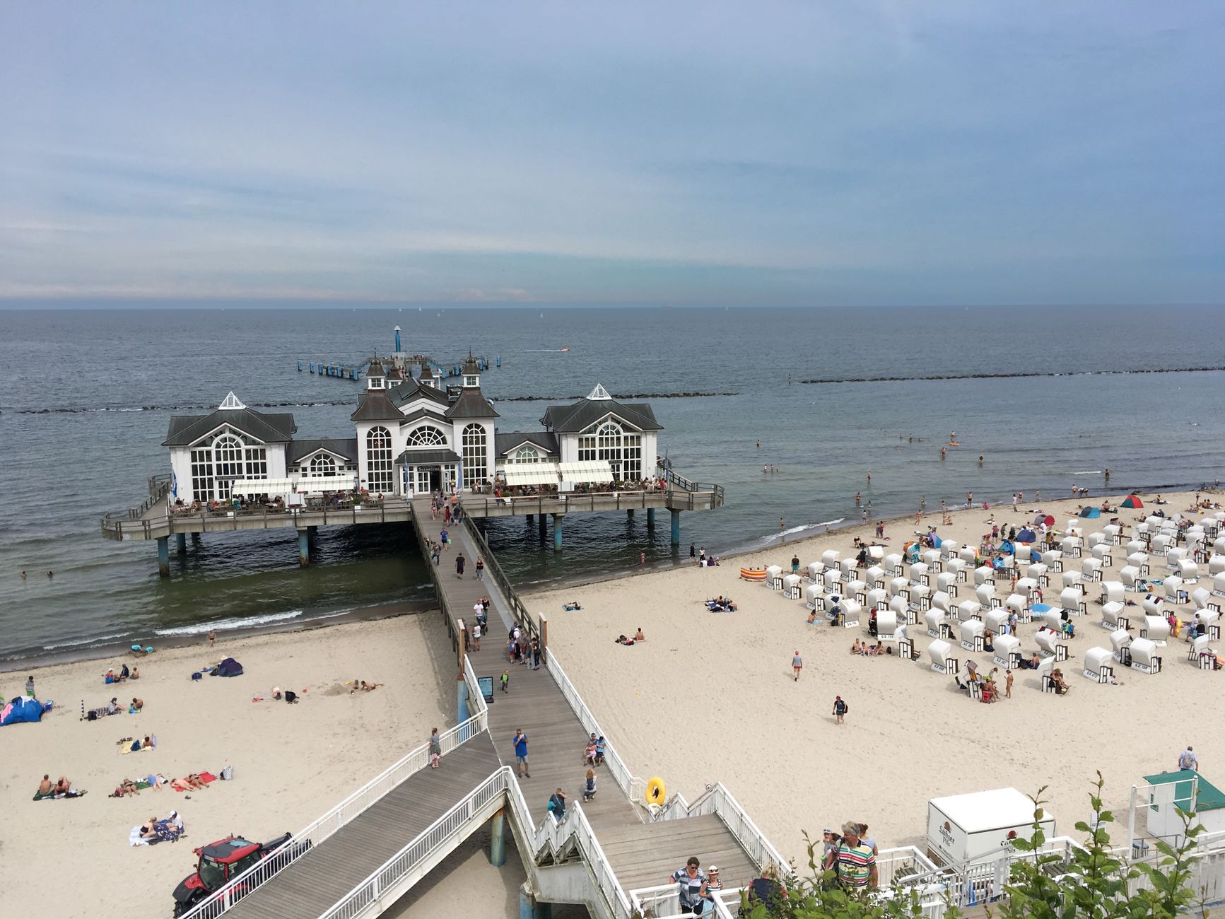 Beautiful aerial view of Sellin Pier with beachgoers, located in Sellin, Germany.