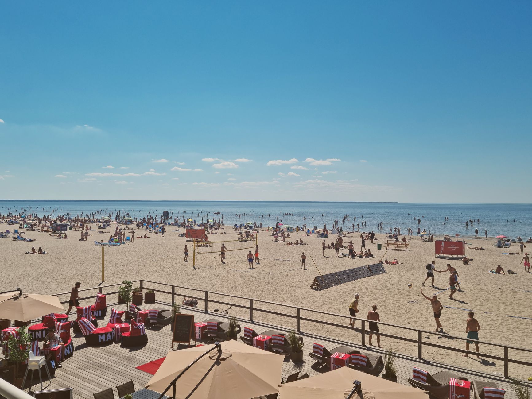 Crowded beach scene in Pärnu, Estonia with people enjoying a sunny summer day by the sea.