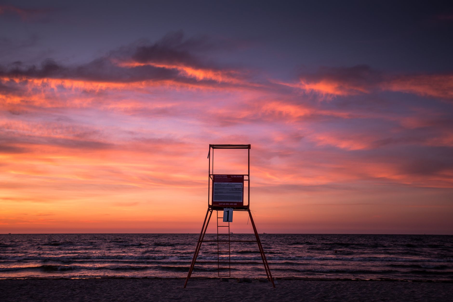 A serene sunset over the Baltic Sea with a lifeguard tower in Świnoujście, Poland.