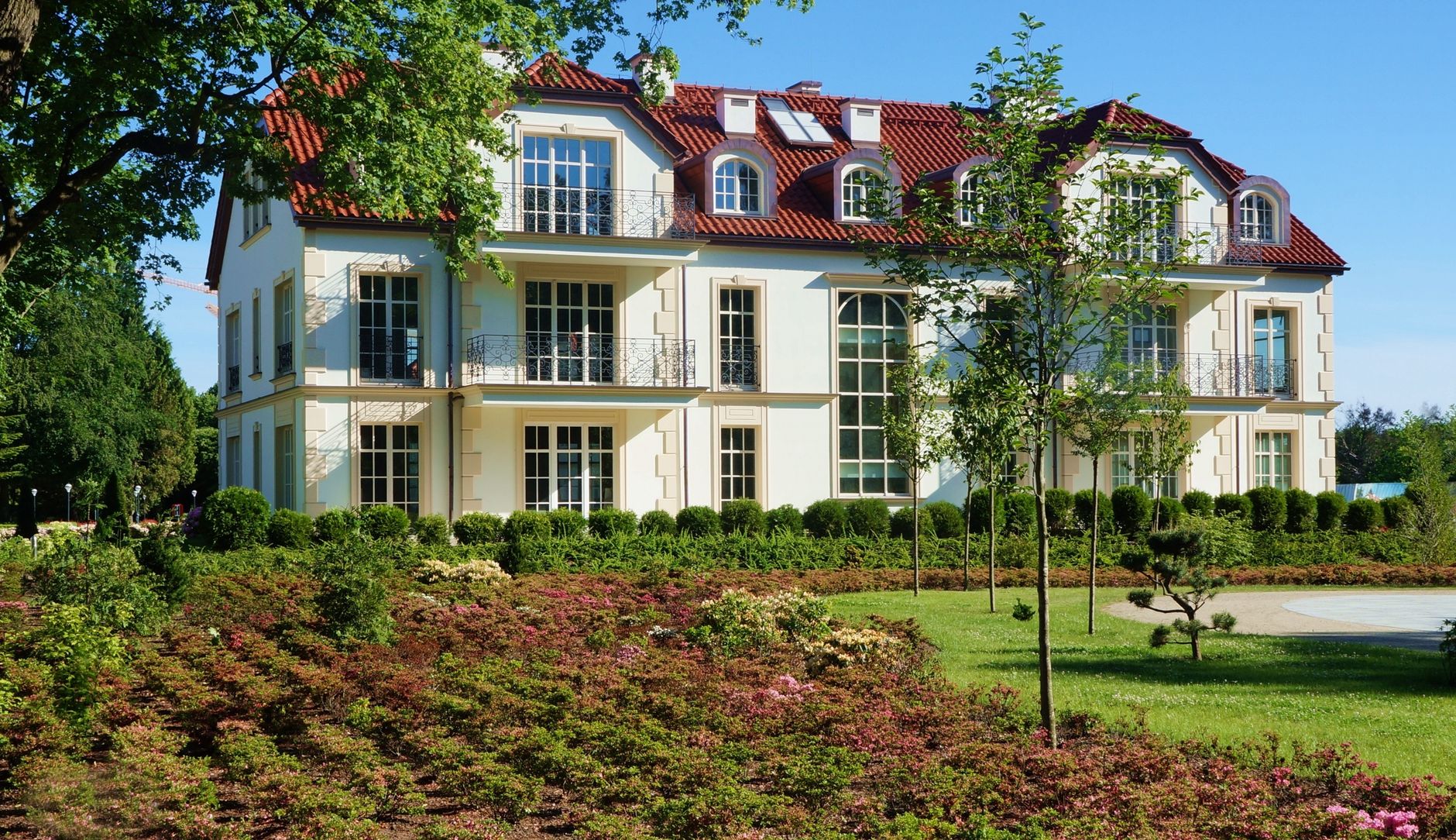 Sunlit residential building with lush garden in Gdansk Oliwa, Poland.