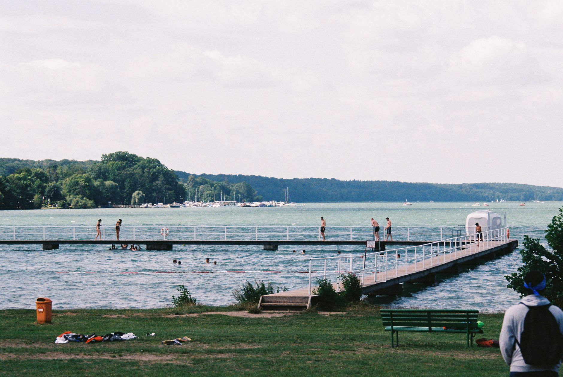 Relaxing summer day with people enjoying a scenic lakeside wooden dock.