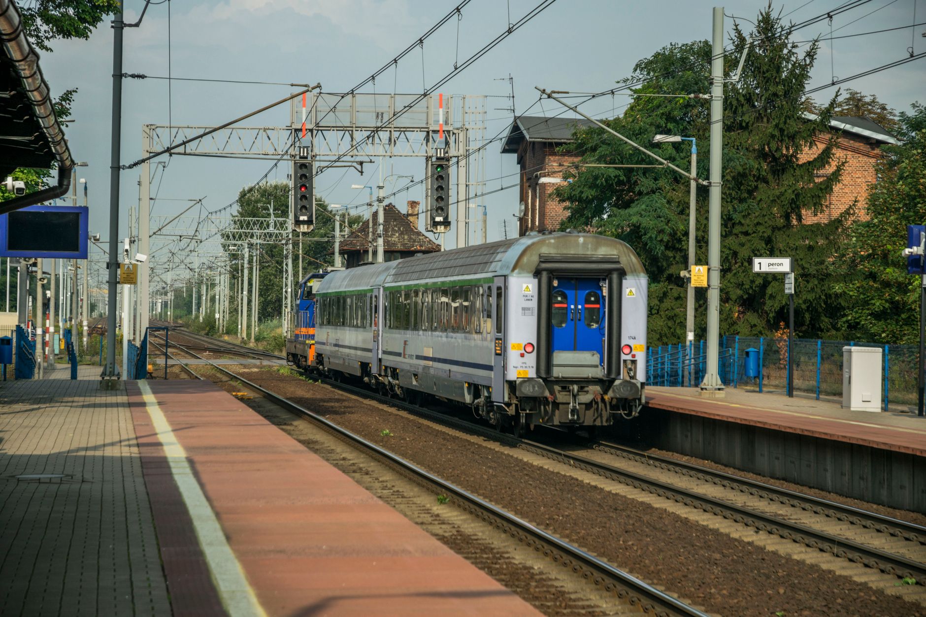 A passenger train departing from a railway station in Wrocław, Poland, showcasing urban transportation.