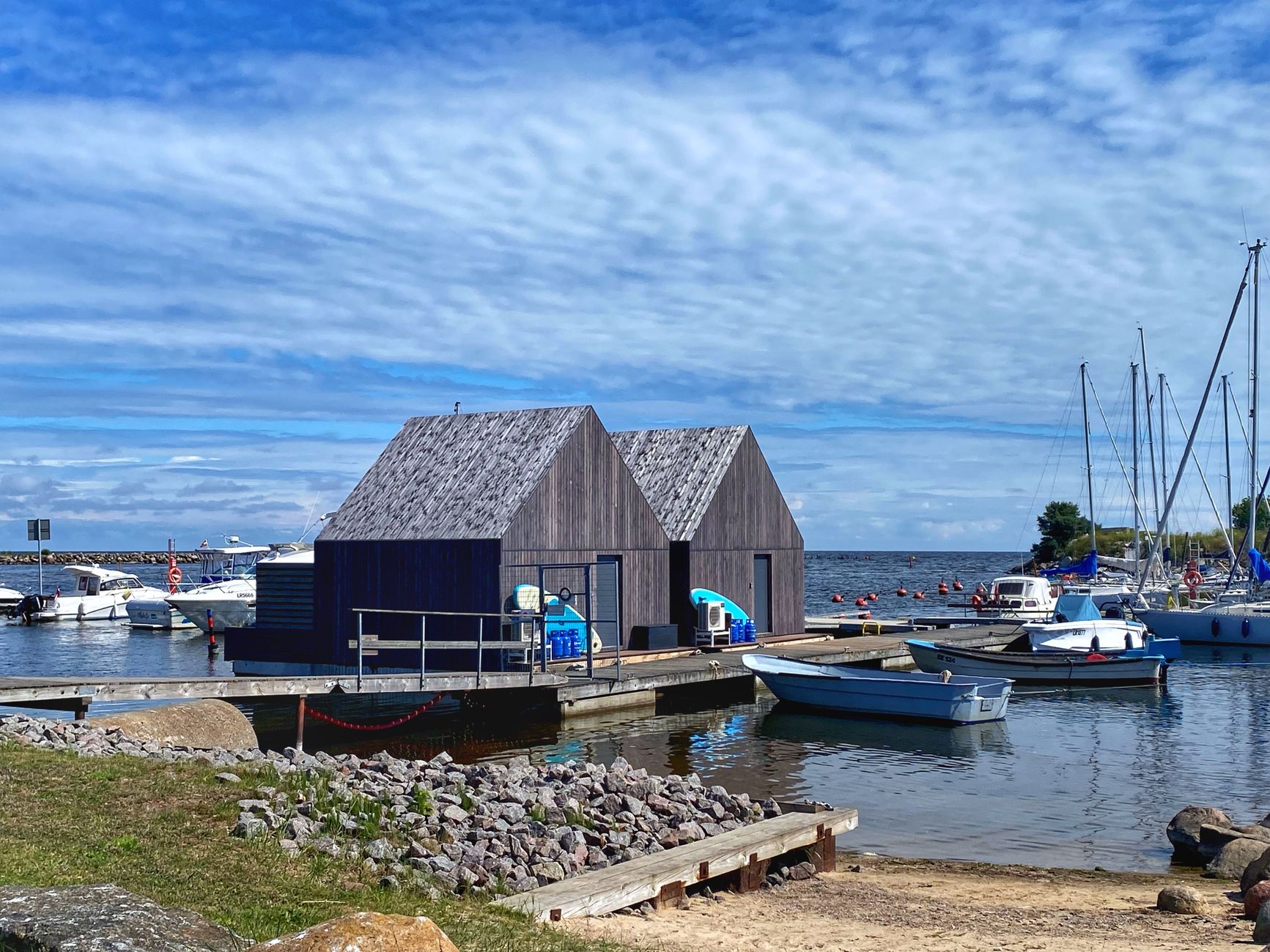 Beautiful marina scene with boats and wooden houses on a sunny day in Engure, Latvia.