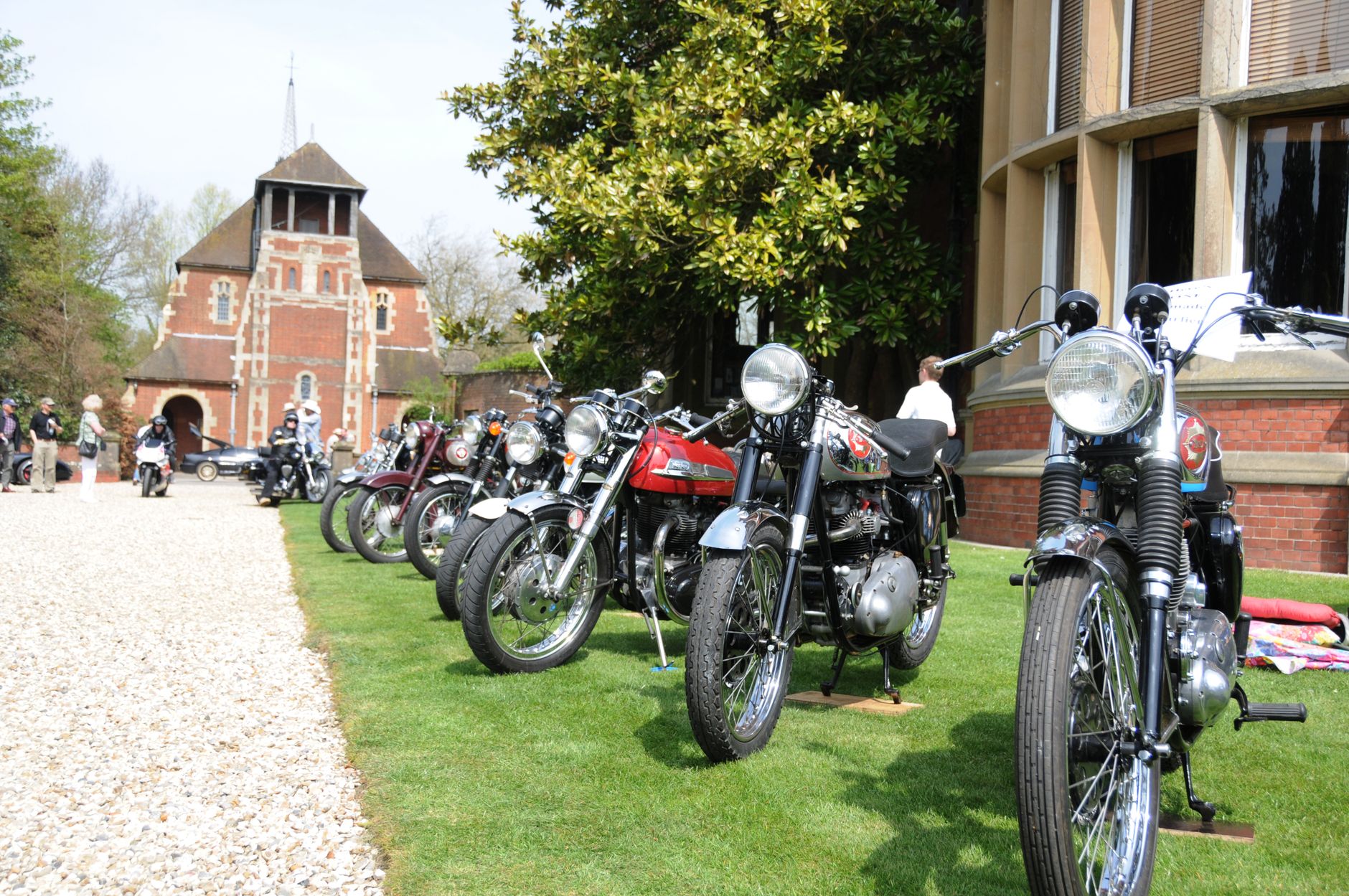 A lineup of vintage motorcycles displayed outdoors at a public show.