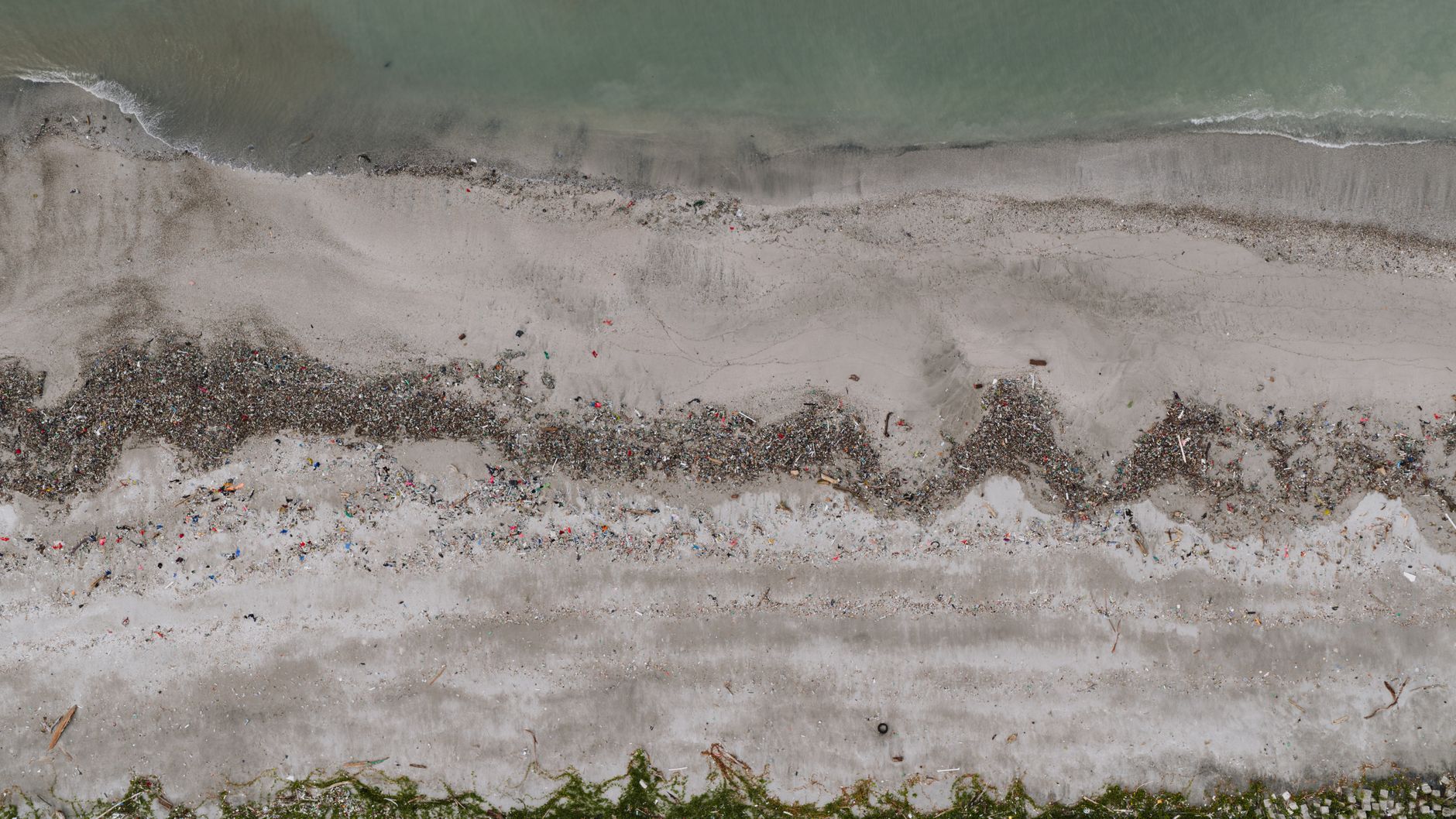Drone shot of ocean pollution along a beach in Panama City, showcasing environmental impact.