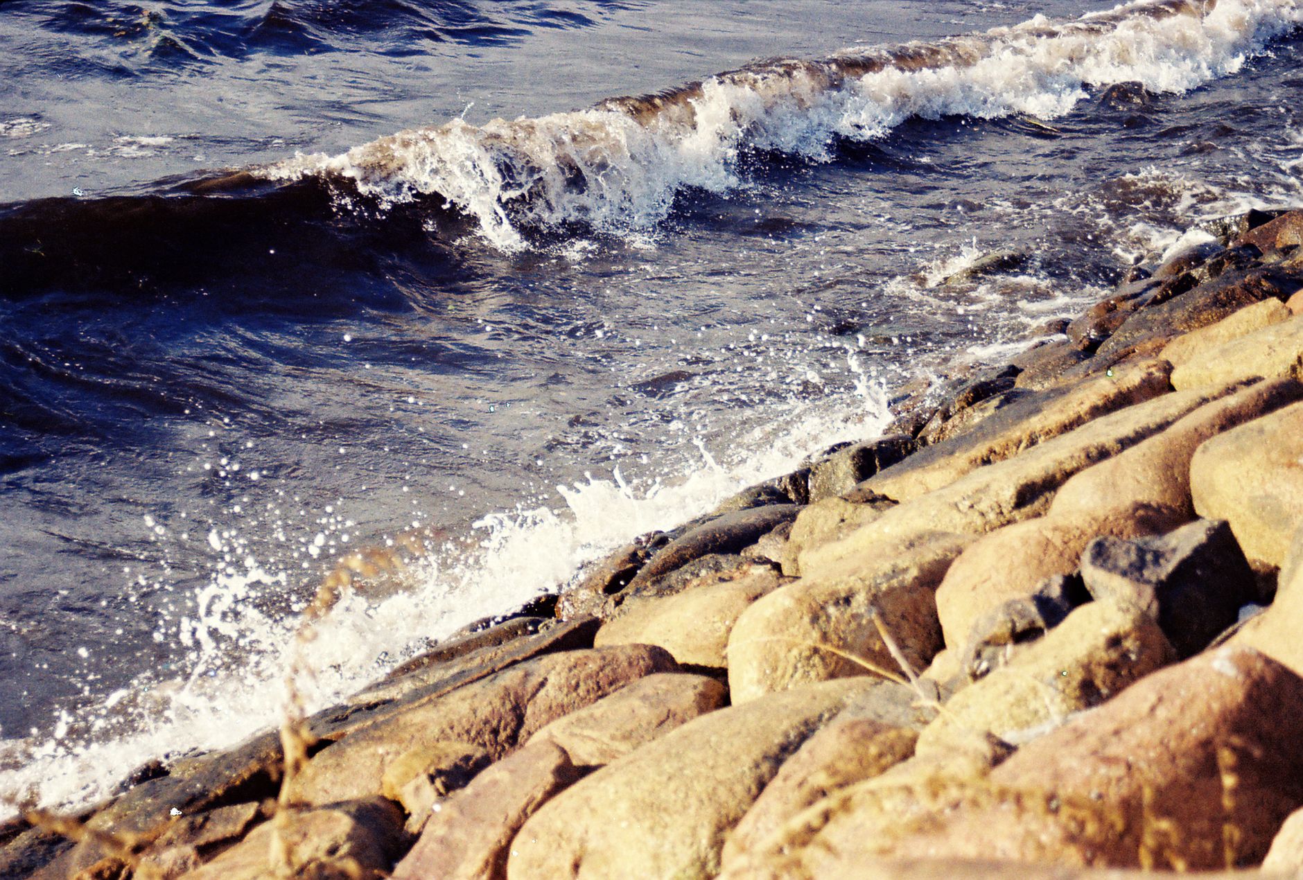 Waves crashing onto a rocky shoreline at Gdańsk, Poland, capturing coastal beauty.