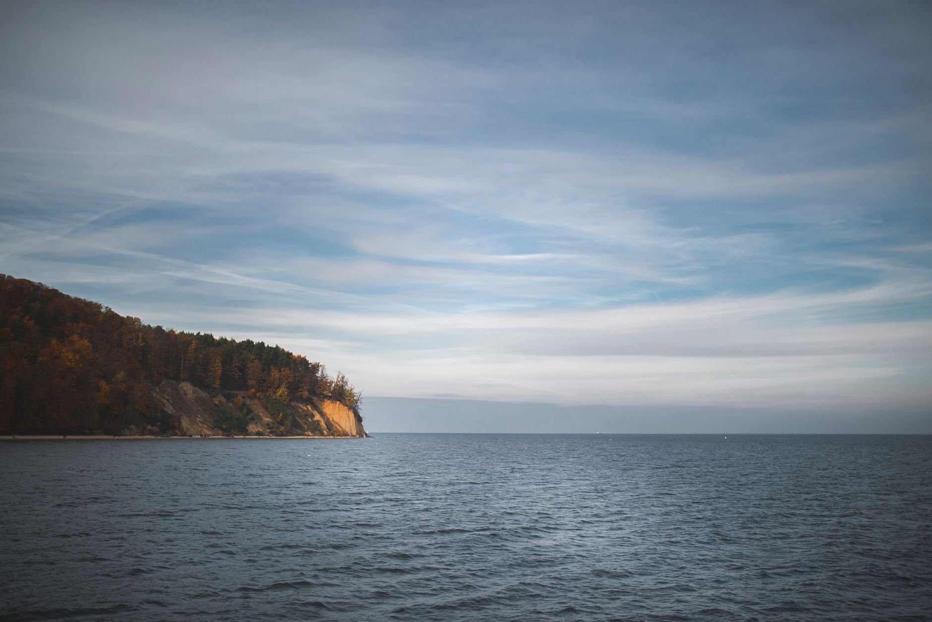 A tranquil view of cliffs and ocean under a dramatic sky in Gdynia, perfect for seascape lovers.