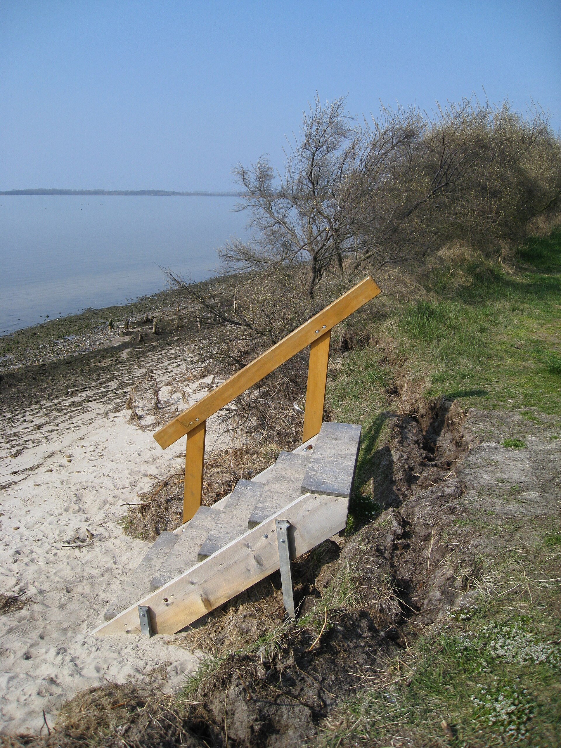 Unstable stairs at a shallow sandy cliff at the Baltic Sea coast near Rerik due to erosion.