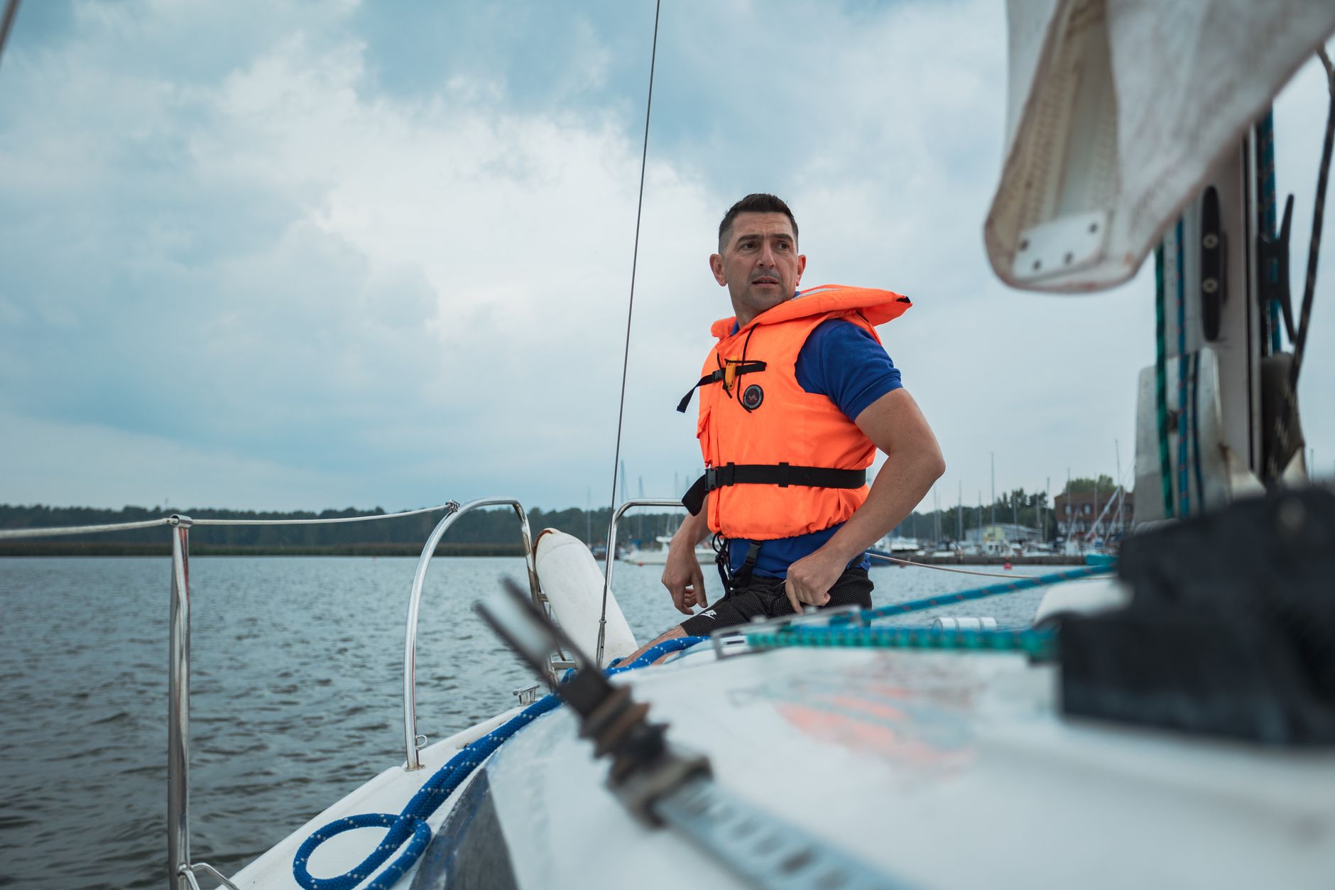 A man in a life vest sailing on a lake, showcasing adventure and safety.