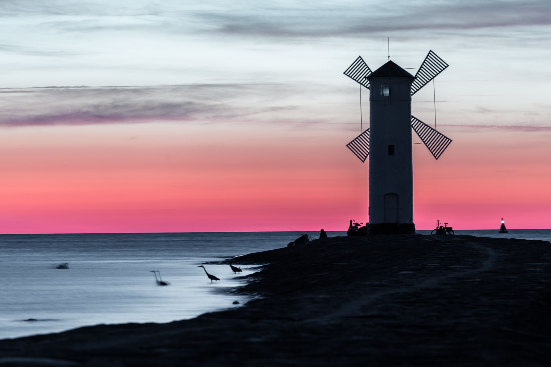 Peaceful sunset view of Stawa Młyny lighthouse on the Świnoujście coastline.